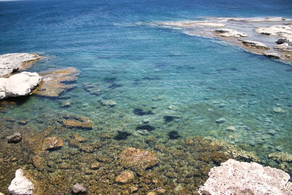 Güzel mavi suları olan kayalık bir sahil.