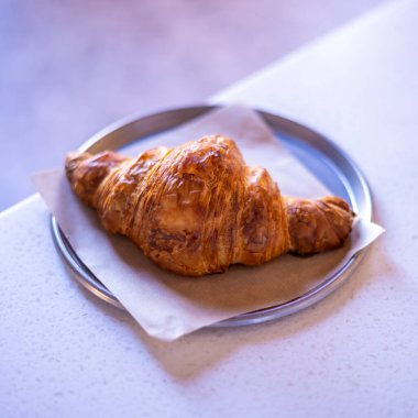 Fresh croissant on white marble table.