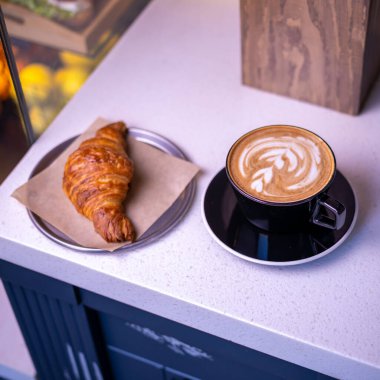 Sıcak kahve ve kruvasan mermer bir tablo