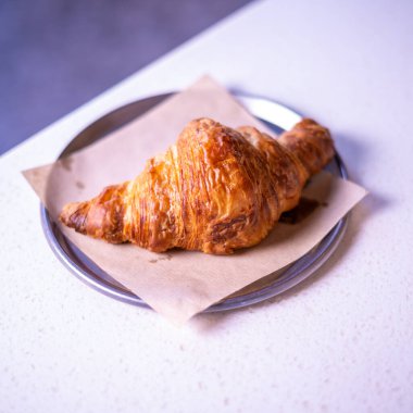 Fresh croissant on white marble table.