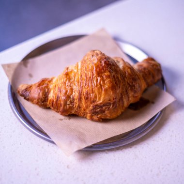 Fresh croissant on white marble table.