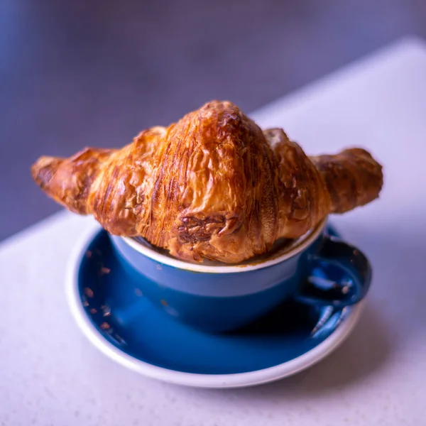 Croissant on cup of coffee. Marble backgroun