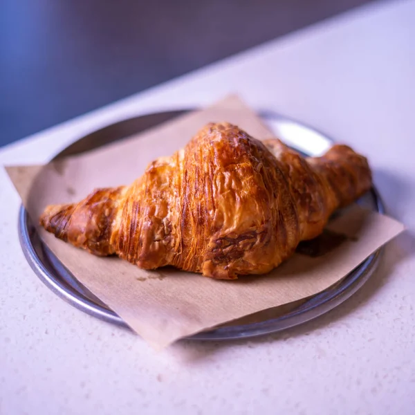 Fresh croissant on white marble table.