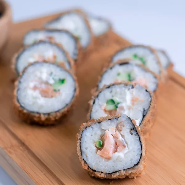 Baked sushi rolls. Hot fried Sushi Roll with salmon, avocado and cheese. Sushi menu.