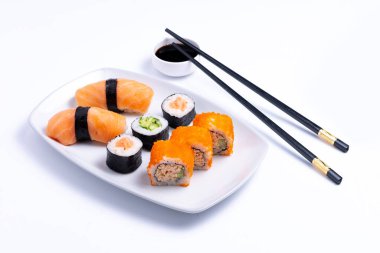 Sushi plate on white background. Makizushi. Delicious sushi rolls on white plate with chopsticks and wasabi. Maki