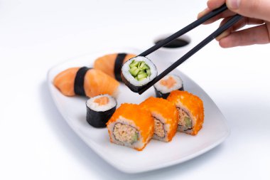 Sushi plate on white background. Makizushi. Delicious sushi rolls on white plate with chopsticks and wasabi. Maki
