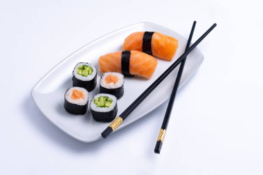 Sushi plate on white background. Makizushi. Delicious sushi rolls on white plate with chopsticks and wasabi. Maki