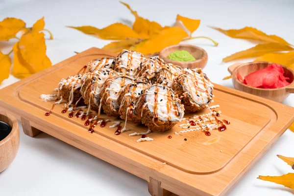 Baked sushi rolls. Hot fried Sushi Roll with autumn and leaves