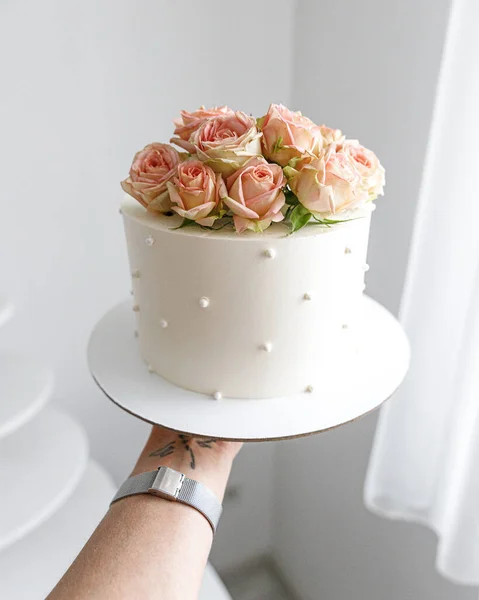 Weiße Torte Rosa Blumen Rosenhochzeit halten an der Hand Stockbild