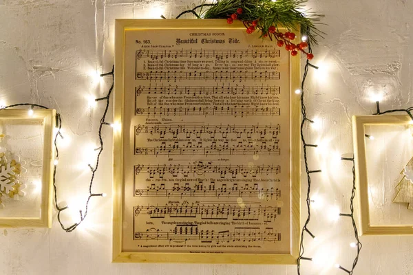 Hoja de música navideña con notas Luces de Navidad y árbol Fotos de stock