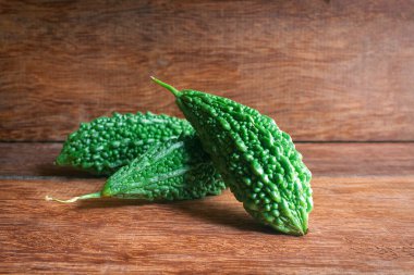 Vahşi acı kabak ya da ahşap bir arka planda acı salatalık. Antioksidan kaynakları açısından zengin, bazı sağlık sorunları için risklerin azaltılmasına yardımcı oluyor.