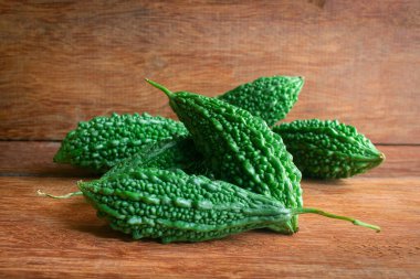 Vahşi acı kabak ya da ahşap bir arka planda acı salatalık. Antioksidan kaynakları açısından zengin, bazı sağlık sorunları için risklerin azaltılmasına yardımcı oluyor.