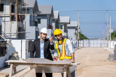 Mimari mühendis toplantısı ve inşaat alanındaki planlarla çalışma, tartışma, tasarım, inşaat konsepti.