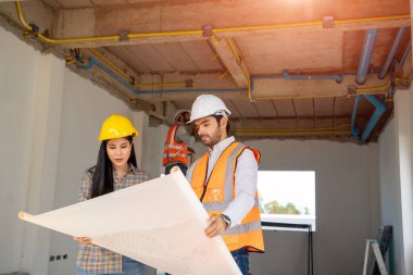 Mimari mühendis toplantısı ve inşaat alanındaki planlarla çalışma, tartışma, tasarım, inşaat konsepti.