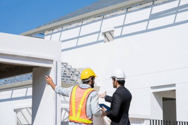 İnşaat sahasında mimar ve ustabaşı buluşuyor, mimar inşaat alanını inceliyor, inşaat projesi kavramını inceliyor..