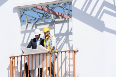 Mimarlık konsepti, mimarlar ve iş adamları inşaat sahasının planlarıyla, inşaat projesi konseptiyle çalışıyorlar..