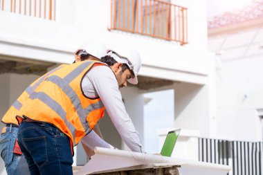 Mimarlık konsepti, mimarlar ve iş adamları inşaat sahasının planlarıyla, inşaat projesi konseptiyle çalışıyorlar..