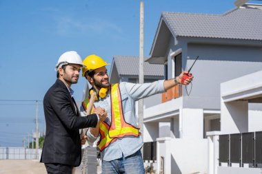 Mimarlar, şantiyedeki inşaat projesi hakkında baş mühendis ile görüştüler.