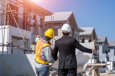 Mimarlık konsepti, mimarlar ve iş adamları inşaat sahasının planlarıyla, inşaat projesi konseptiyle çalışıyorlar..