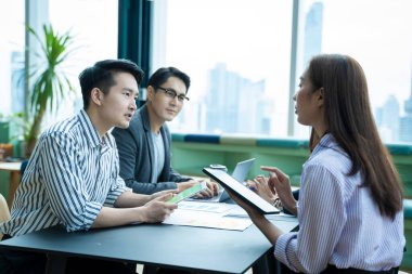 İş ortakları ofiste toplantı ve haberleşme konusunda belge ve fikirleri tartışıyor..