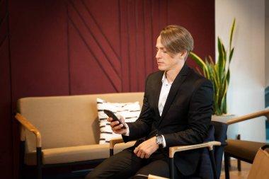 İş adamı akıllı telefonu ofiste çalışır ve konuşur..