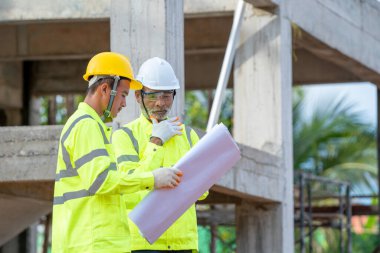 Mimarlar ve mühendisler yeni inşaat sahalarında iş, mühendislik araçları ve inşaat konseptini tartışırlar..