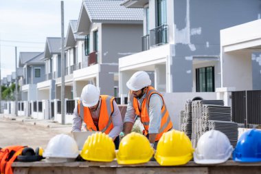 İnşaat şantiyesinde çalışan inşaat mühendisleri grubu inşaat alanında danışmanlık yapıyor inşaat alanında yeni bir ev inşa ediliyor.