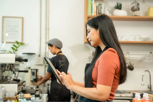 コーヒーショップでタブレットを扱う新規事業主 オーガニックホットドリンク製品を扱う小規模地方事業 — ストック写真