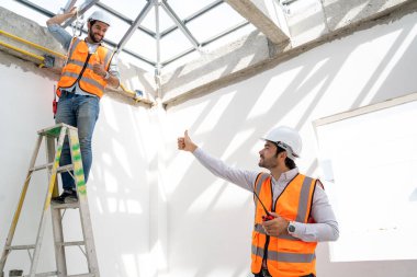 İnşaat alanında çalışan mühendis, mimarlar açık hava inşaatı projesini tartışıyor..