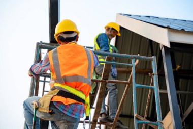 Emniyet kemeri takan inşaat işçisi yüksek mevkide çalışıyor.. 