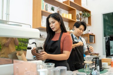 Barista, Kahve Dükkanı 'nda bir fincan Cappuccino hazırlıyor. Profesyonel barista kahve makinesinin üzerine kimya dökümü ve kahve demlemenin alternatif yolları olan su ısıtıcısı kullanarak kahve hazırlıyor..