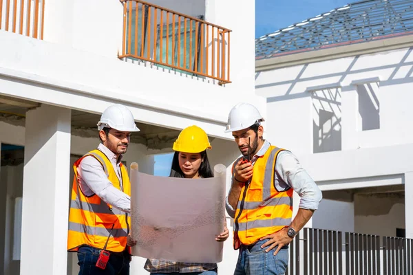 Architect and engineer meeting planning for a new project about detail of building at construction site.