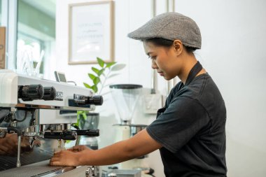 Barista, Kahve Dükkanı 'nda bir fincan Cappuccino hazırlıyor. Profesyonel barista kahve makinesinin üzerine kimya dökümü ve kahve demlemenin alternatif yolları olan su ısıtıcısı kullanarak kahve hazırlıyor..