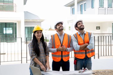 Mühendisler, inşaat alanındaki yeni ev planlarını danışmanlarla tartışıyor..