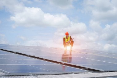 Mühendisler fabrikanın çatısındaki güneş panelini kontrol ediyorlar..