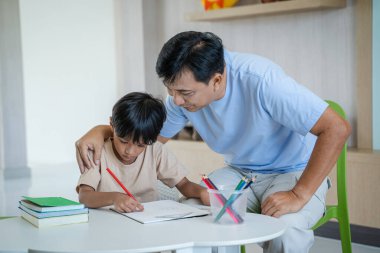 Asyalı anne ve baba ev ödevi öğretiyor çocuklar, mutlu aile evde oturma odasında, aile bireylerinin faaliyetleri iyi eğitimdir..