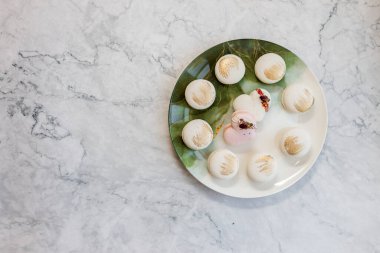 Beyaz badem kurabiyeleri tabakta. Hafif arka planda tabakta nefis hafif kurabiyeler. Fırın