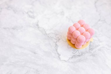 Açık mermer arka planda lezzetli, ilginç hamur işleri. Pembe kremalı pasta.