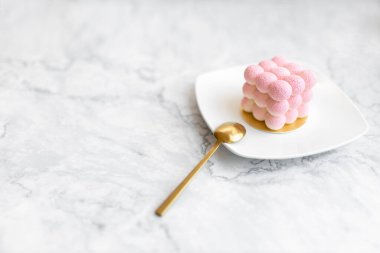 Açık mermer arka planda lezzetli, ilginç hamur işleri. Pembe kremalı pasta.