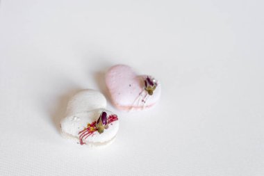 Beautiful tender delicious pastries on a light background. White and pink macaroons on a white canvas. Valentines Day background