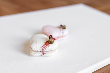 Beautiful tender delicious pastries on a light background. White and pink macaroons on a white canvas. Valentines Day background