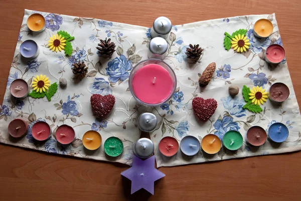 Masada bir sürü mum var. Çeşitli renkler.
