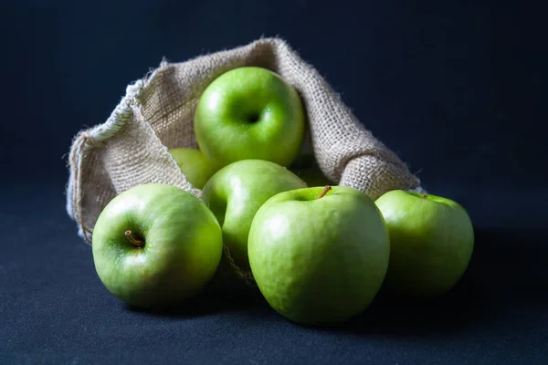 Πράσινα Μήλα Είναι Στην Τσάντα Και Στο Τραπέζι Σκοτεινό Φόντο Εικόνα Αρχείου