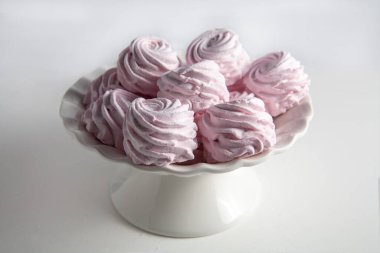 Masanın üzerindeki vazoda bir şekerleme var. Beyaz bir arka planda. Seçici odak.