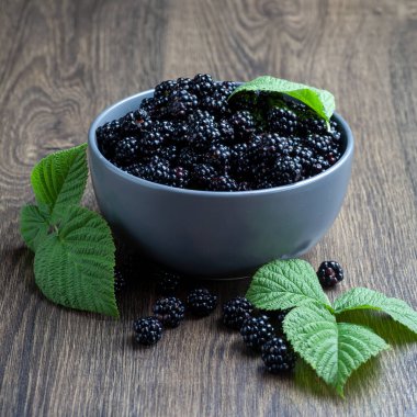There is a blackberry in a bowl on the table.