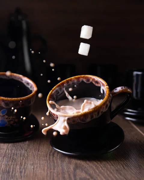 Masanın üzerinde bir kupa kahve var. Spreylerin uçtuğu yer. Alçak tuş.