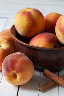 Masada bir tabakta kayısılar var. Tabağın yanında üç kayısı var..