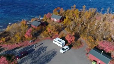 İsveç sonbahar renkleri sırasında Abisko 'dan Bjoerkliden' e doğru göl kenarına park eden araba kampı karavanı.