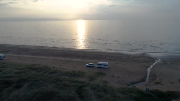 50fps anténa Sunset Pár se psem na venkovní dovolené karavan camper na pláži Melby, Švédsko u oceánu — Stock video