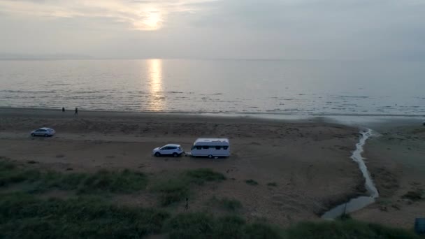 50fps aéreo Pôr do sol Casal com cão em férias ao ar livre caravana campista na praia de Melby, Suécia pelo oceano — Vídeo de Stock